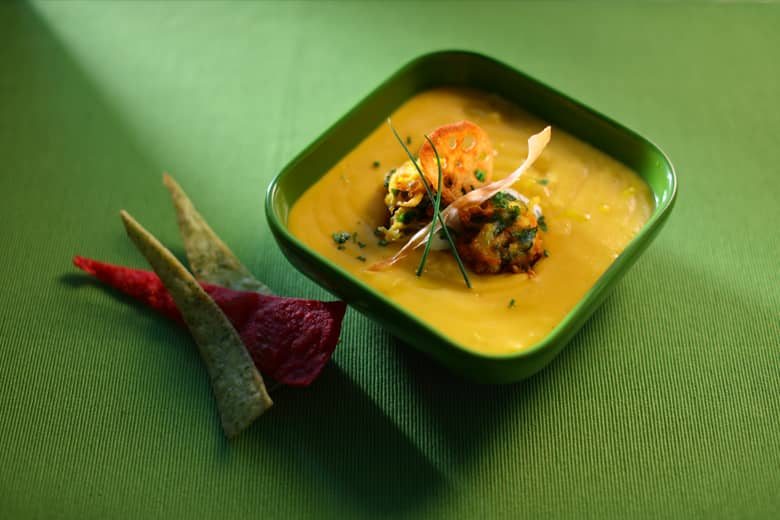 Vegan bowl food served in a green square bowl.
