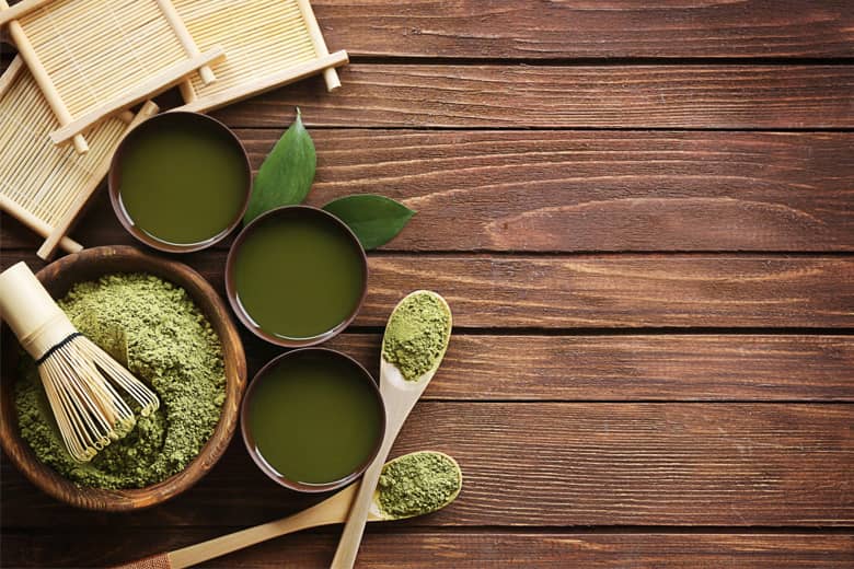 Wood board with whisk, green tea and bamboo.