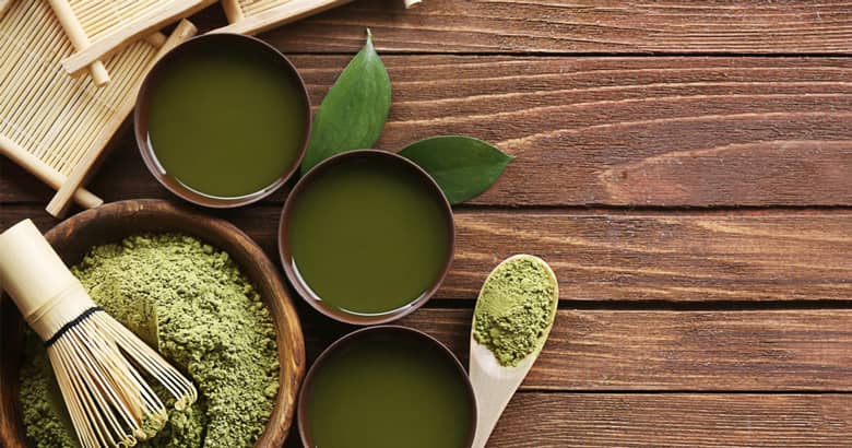 Wood board with whisk, green tea and bamboo.
