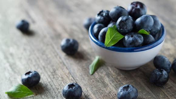 A bowl of blueberries on a counter.