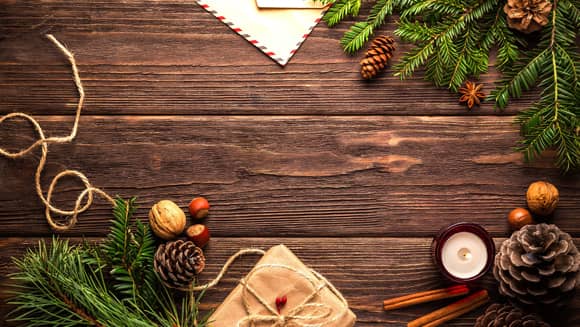 Christmas theme with wood, branches, cinnamon, envelopes and parcel tied with string.