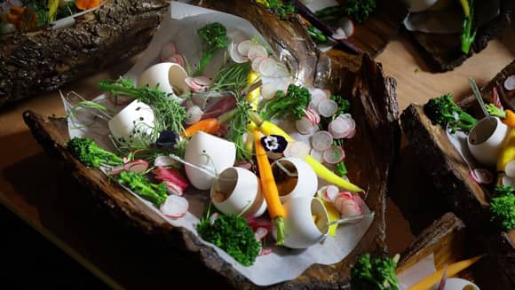 Family feast with egg shells filled with pumpkin mousse on bark platters.