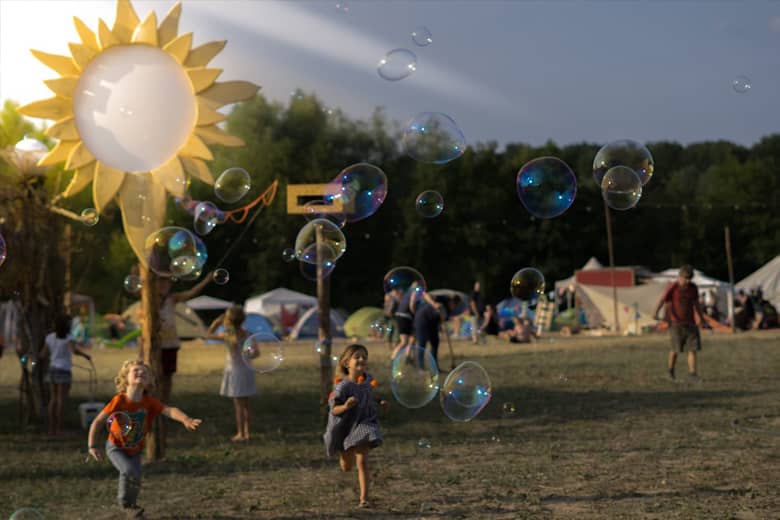 Festival Theme with tents and children chasing bubbles.