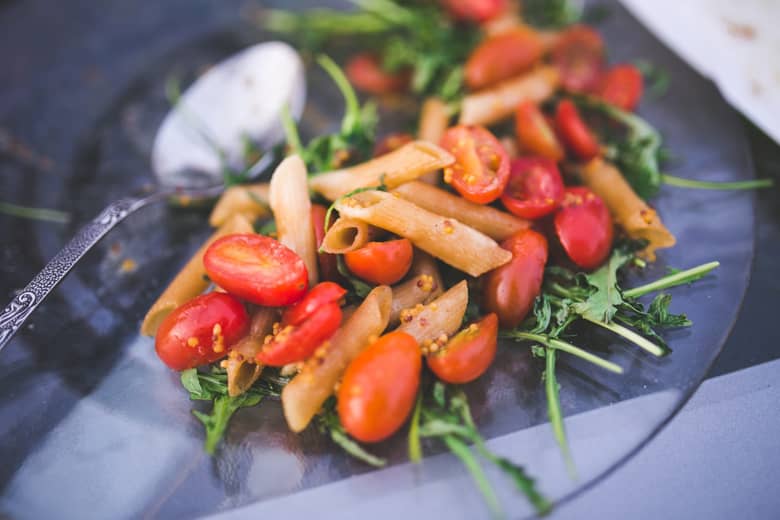 Vegetarian pasta meal on a dish with spoon.