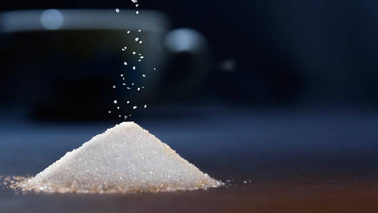 A pile of granulated sugar pouring from above.