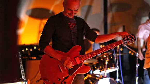 A band guitarist tuning his guitar.