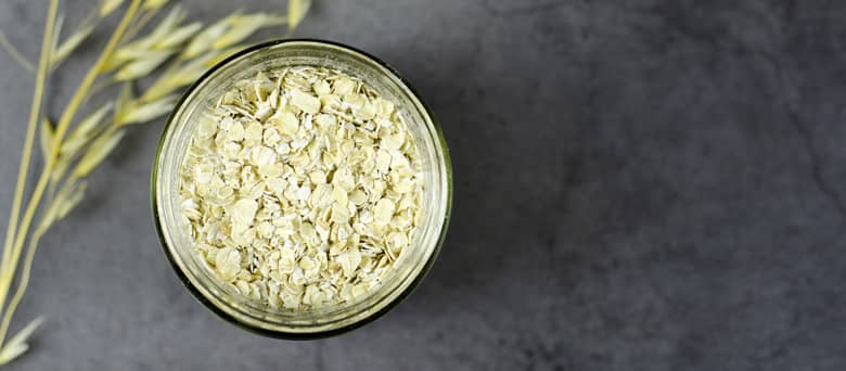 Jar of oats on grey.