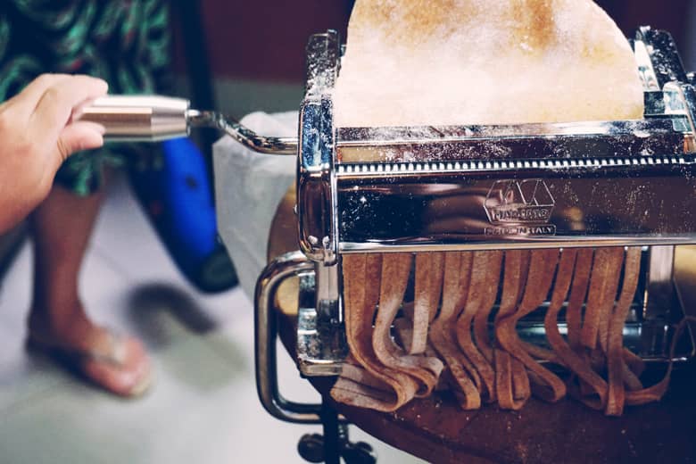 Fresh pasta being made with a pasta machine.