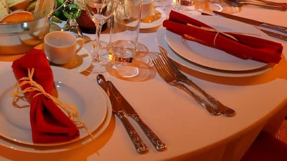 Place settings with red napkins wrapped with straw raffia.