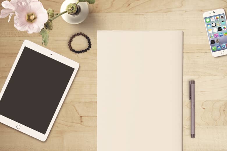 Desk with tablet, paper, pen and mobile phone.