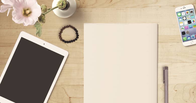 Desk with tablet, paper, pen and mobile phone.