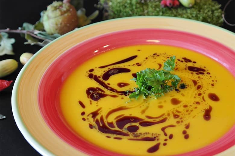 A colourful bowl of pumpkin soup.