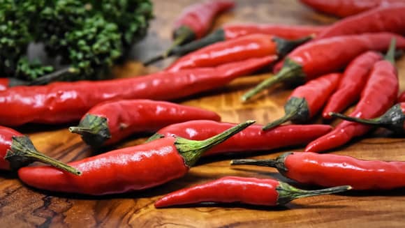 Fresh red chilli peppers on a wood kitchen board.