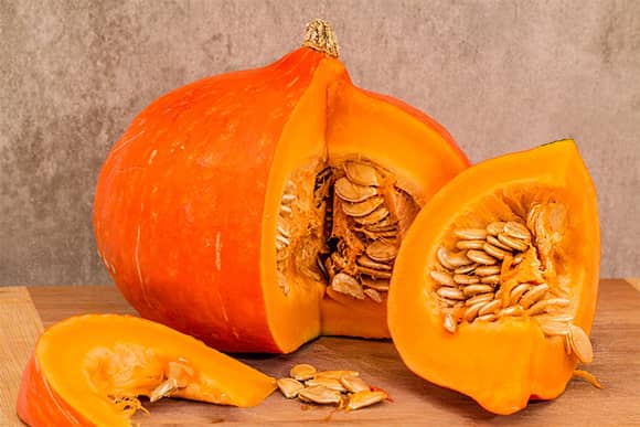 A freshly sliced pumpkin open with seeds.