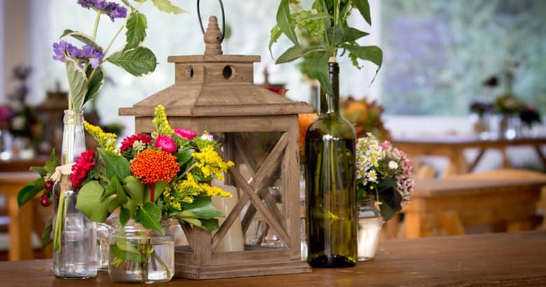 Table centrepiece by PenniBlack with lantern and fresh wild flowers in jars.