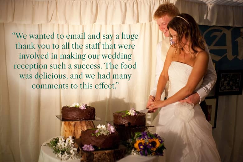 Bride and groom cutting their wedding cake at a wedding reception by PenniBlack.