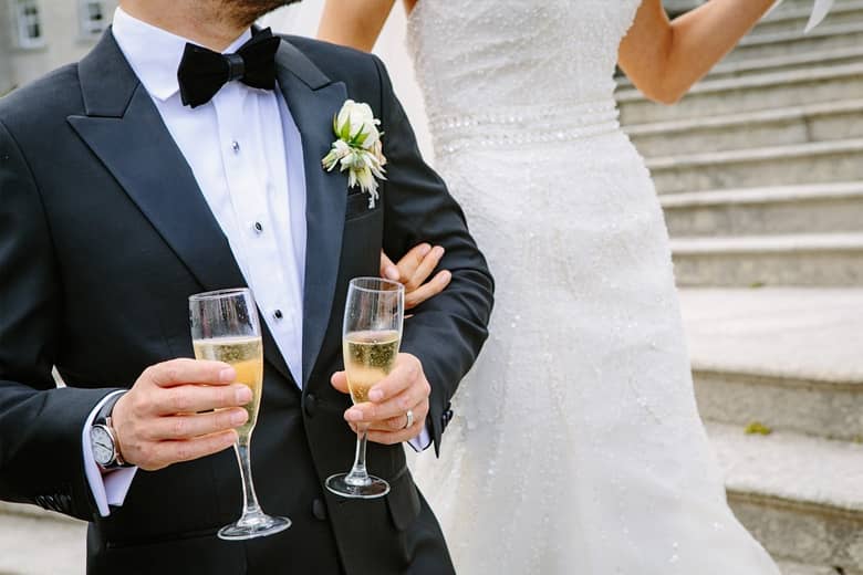 Bride and groom with champagne flutes for a toast.