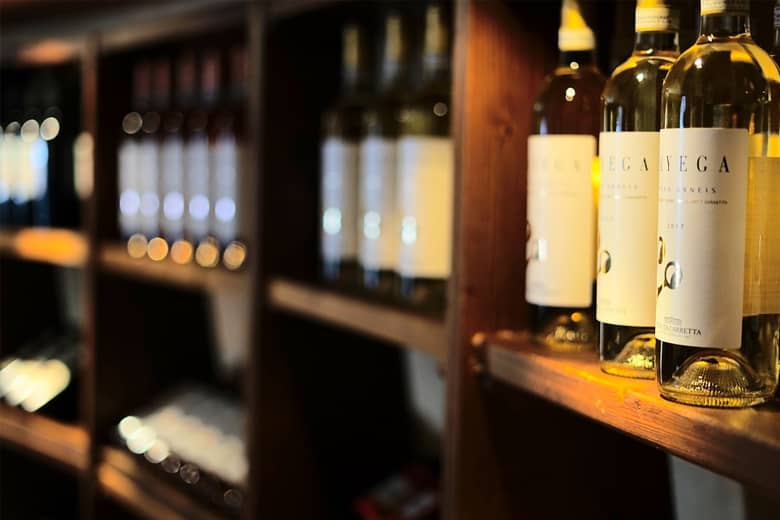 A series of shelves filled with wine bottles.