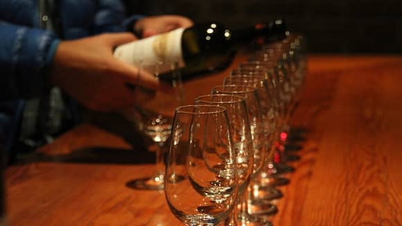 Wine being poured into tasting glasses.