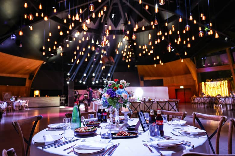 Venue setup for an event with lighting, tableware, and entertainment.