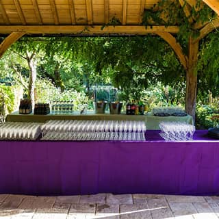 The outdoor bar setup with glasses and themed wild flower decorations.