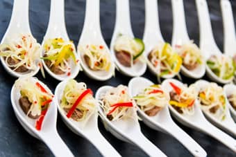 Seared tuna niçoise with a papaya salad on a Chinese spoon.