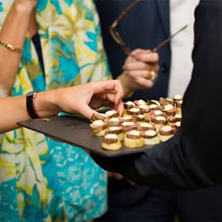 PenniBlack staff serving baby venison canapés to guests.