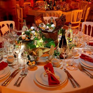 Banquet table set with red and gold decorations and a central winter garden themed feast.