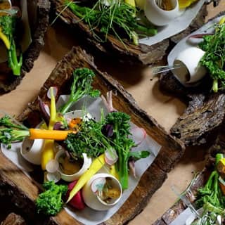Egg shells filled with pumpkin mousse and truffle foam on bark platters.