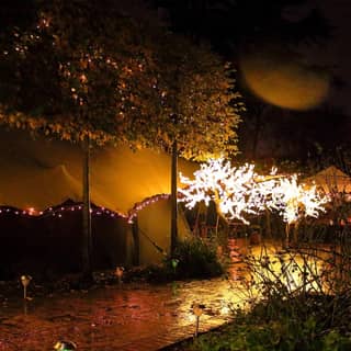 Exterior of the tent lit up at night.