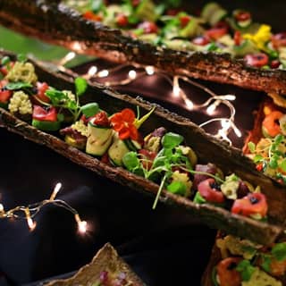 Finished bark platters filled with canapés and dressed with twinking lights.