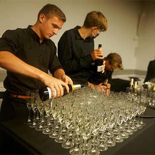 PenniBlack barstaff preparing glasses of bubbles.