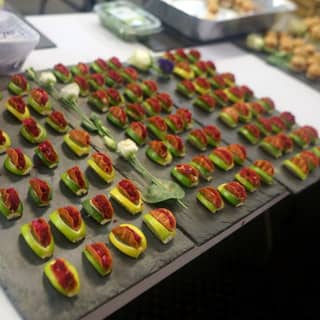 Preparing slates of beetroot taco boats and mini cheeseburger arrival canapés.