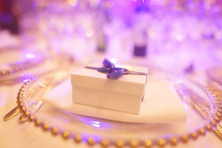 Beautiful favour box tied with ribbon on a place setting.
