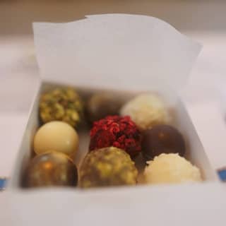 Favour box open with a selection of luxurious handmade assorted truffles inside.