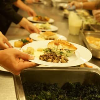 Chefs preparing the hazelnut crusted halibut main course.