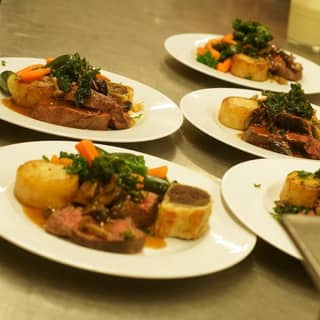 Chefs preparing the beef sirloin pulled beef wellington main course.