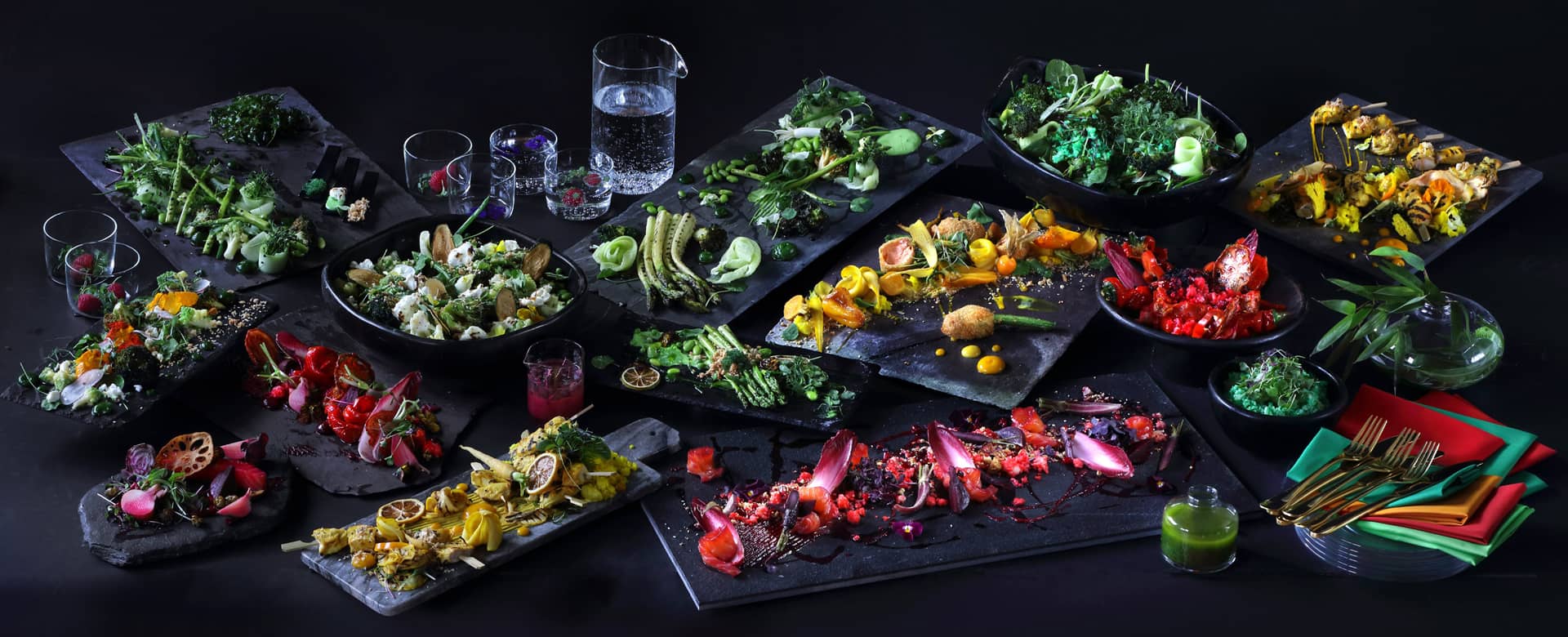 A selection of plant-based food served on black slate.