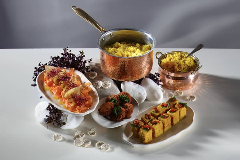 Dosha food arranged in copper pots and styled with rocks.