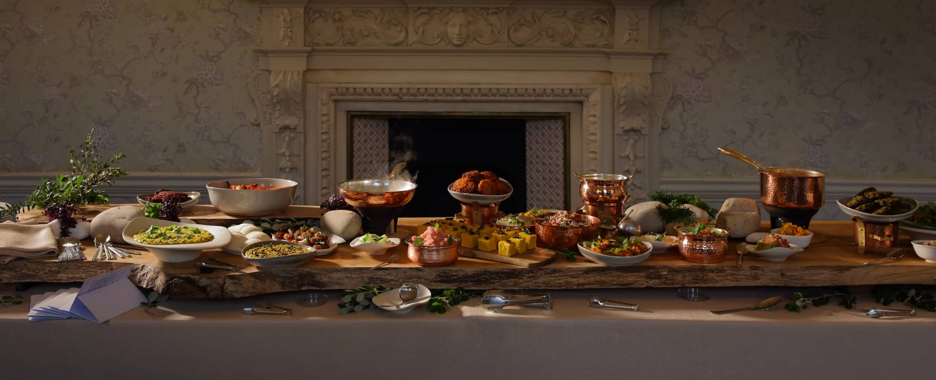 Food styled along a wooden table, steaming and freshly prepared.