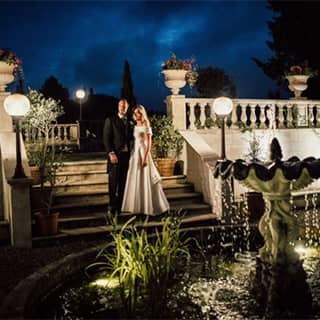 Bride and groom by the fountain in the evening.